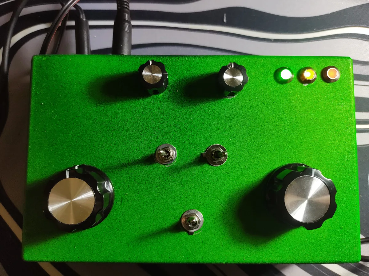 Green handmade Sirenotron analog dub siren with knobs, switches and lit LEDs